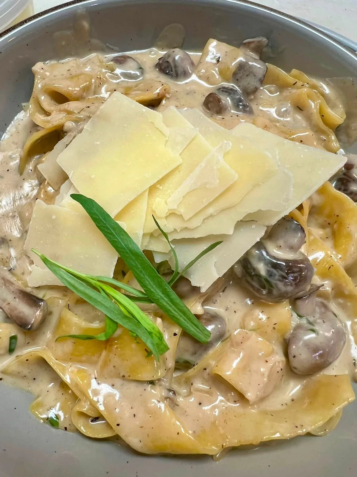 Creamy mushroom pappardelle topped with shaved parmesan and herbs